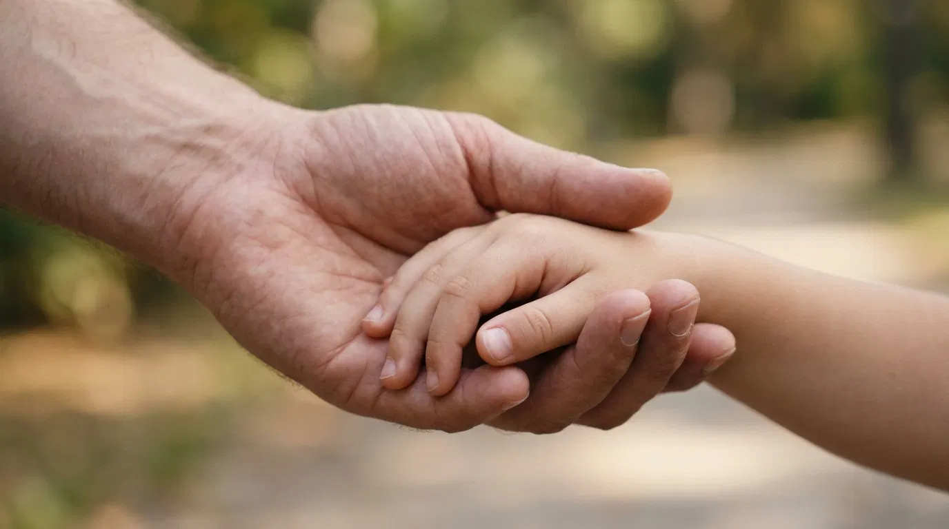 A Child's Hand Held in a Large Hand